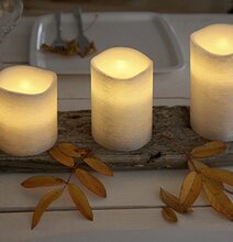 Bild av stilrena ljuslyktor på rustikt träfat