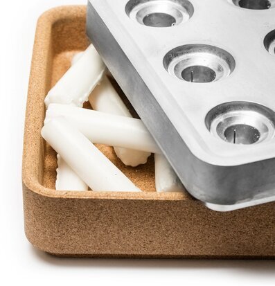 Bild av korkskål med ljus och metallform i harmoni