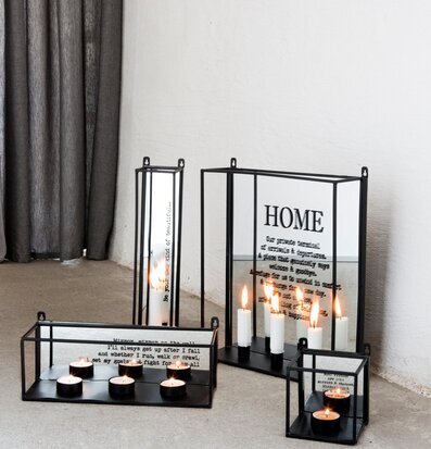 Bild av ljuslyktor mot betonggolv och krämvit vägg