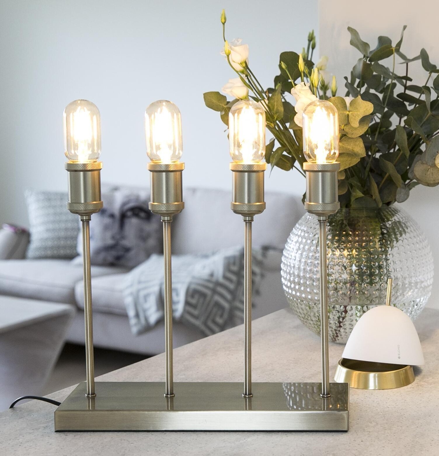 Bordslampa Mässing från Havsö på grått bord med glasvas