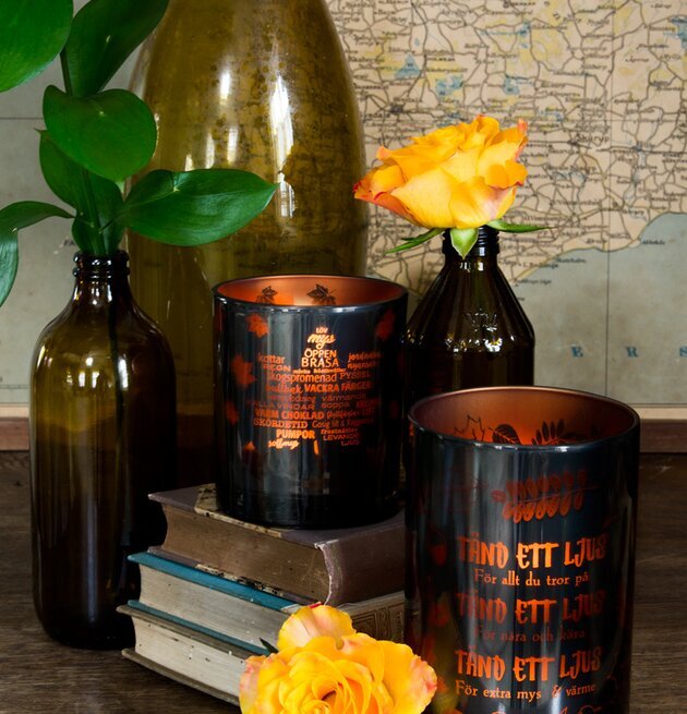 Tänd Ett Ljus - Majas Cottage på rustik bok med glasflaskor