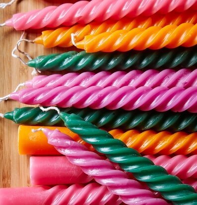 Bild av färgglada spiralformade stearinljus på träyta