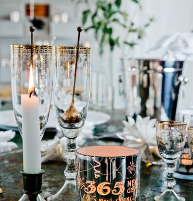 Bild av festligt uppdukad yta med glas och ljuslyktor