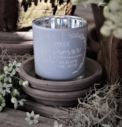 Bild av ljuslykta med text för mormor i naturlig miljö