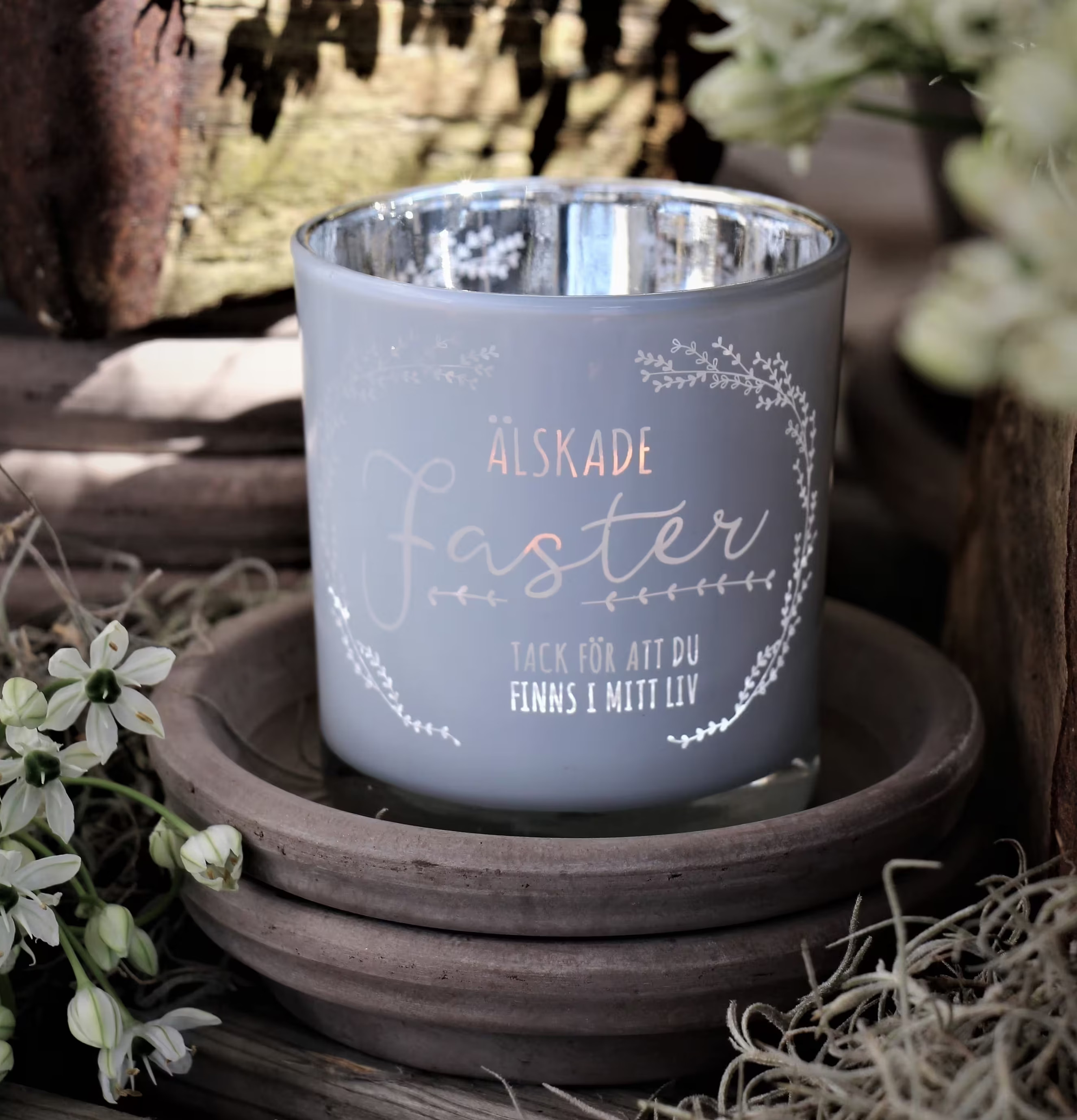 Foto av stilren ljuslykta med dekorativ text och blommor