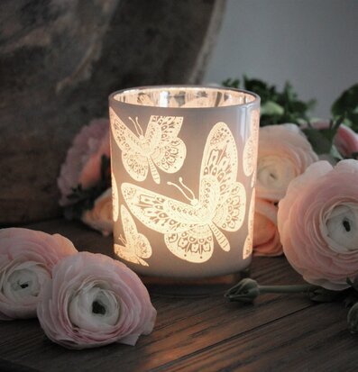 Bild av ljuslykta med fjärilsmönster och blommor