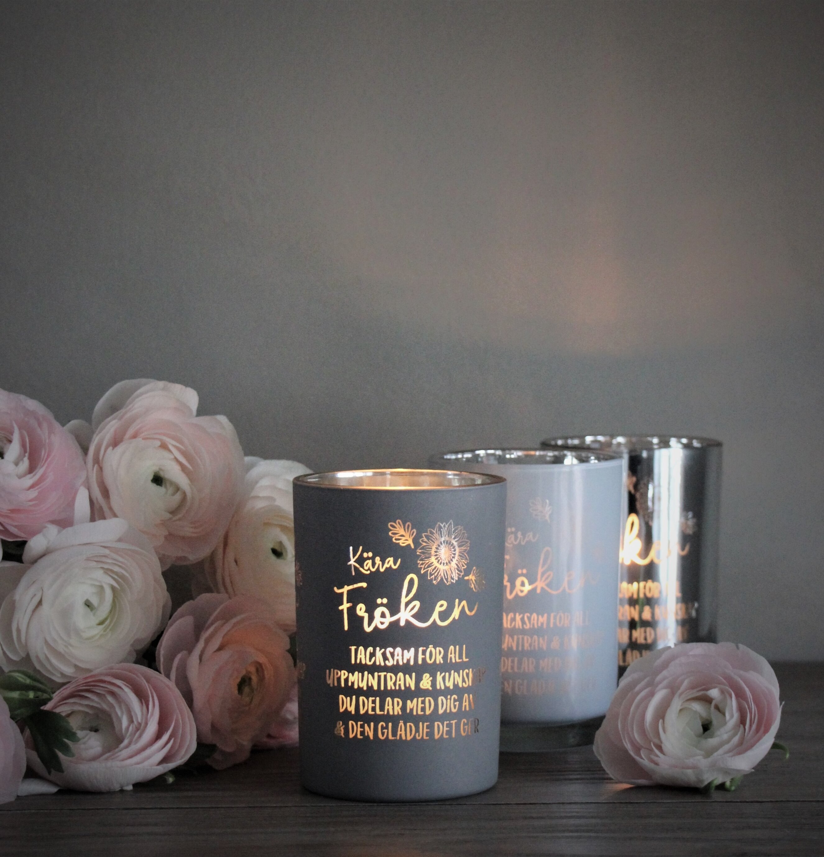 Bild av eleganta ljuslyktor med blommor i förgrunden