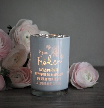 Bild av ljuslykta med blommor och inspirerande text