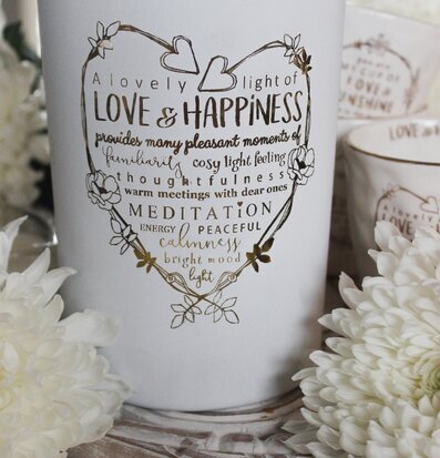 Foto av elegant ljuslykta med gyllene text och blommor