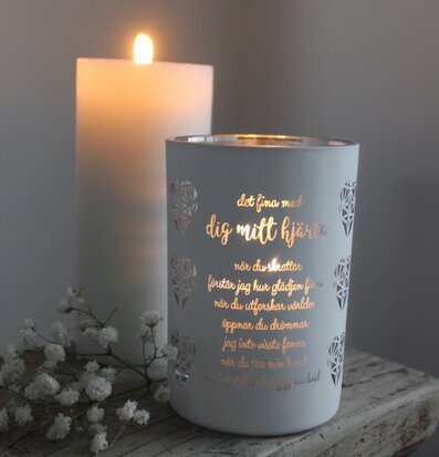 Bild av elegant ljuslykta med poetisk text och blommor