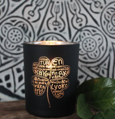 Foto av ljuslykta med fyrklöverdesign och skuggspel