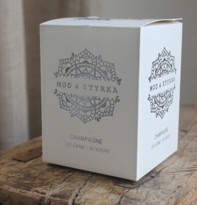 Bild av stilren förpackning med doftljus på träbord