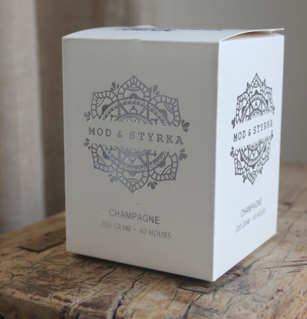 Bild av stilren förpackning med doftljus på träbord