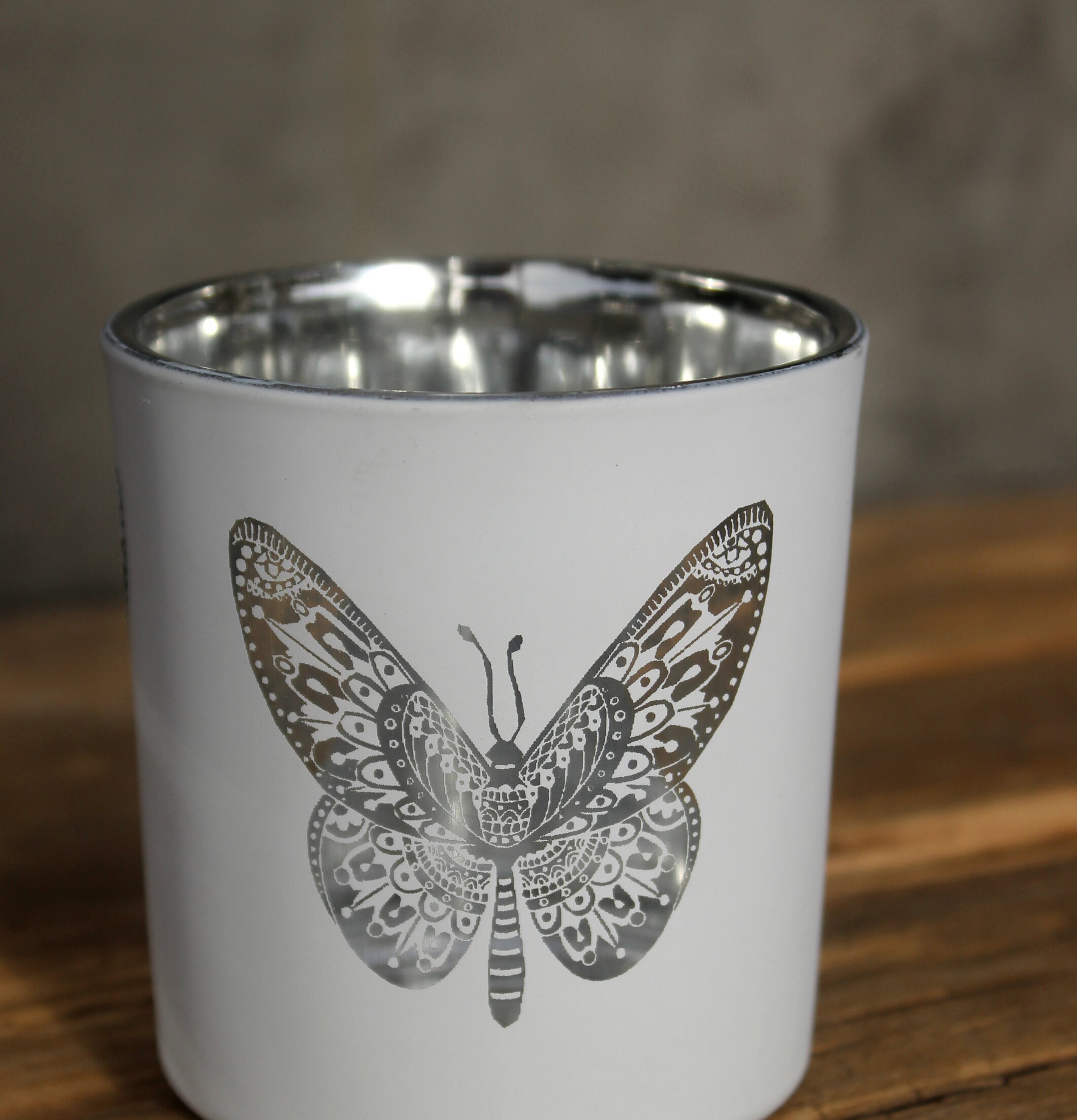 Bild av ljuslykta med fjärilsdesign i vit och silver