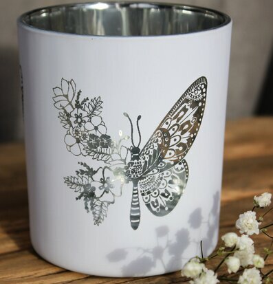 Bild av stilren ljuslykta med fjärilar och blommor