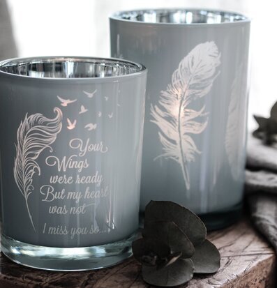 Bild av ljuslyktor med fjädermotiv och eukalyptusblad