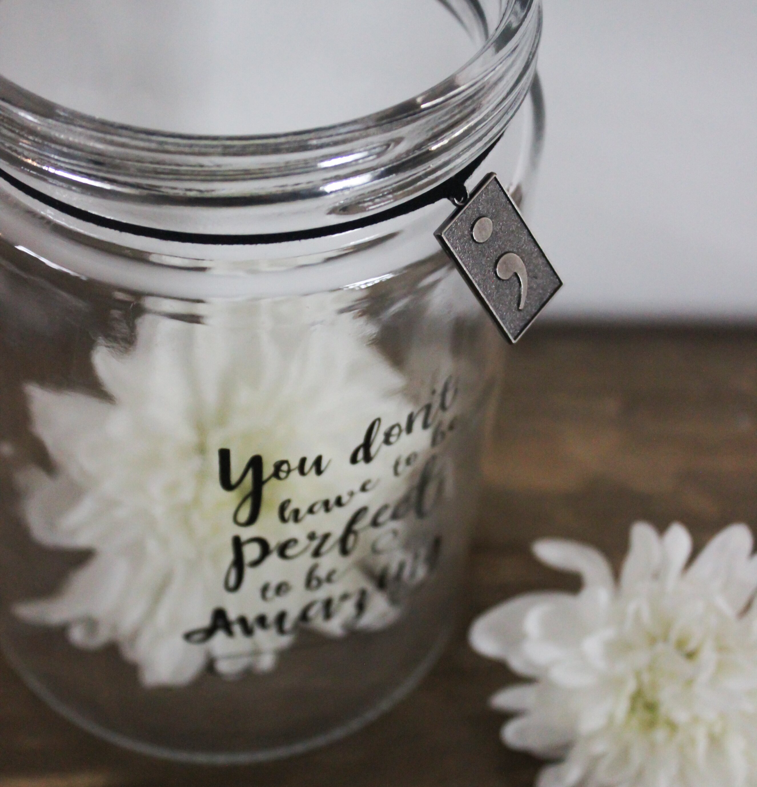 Bild av glaslykta med inspirerande text och dekorativ berlock