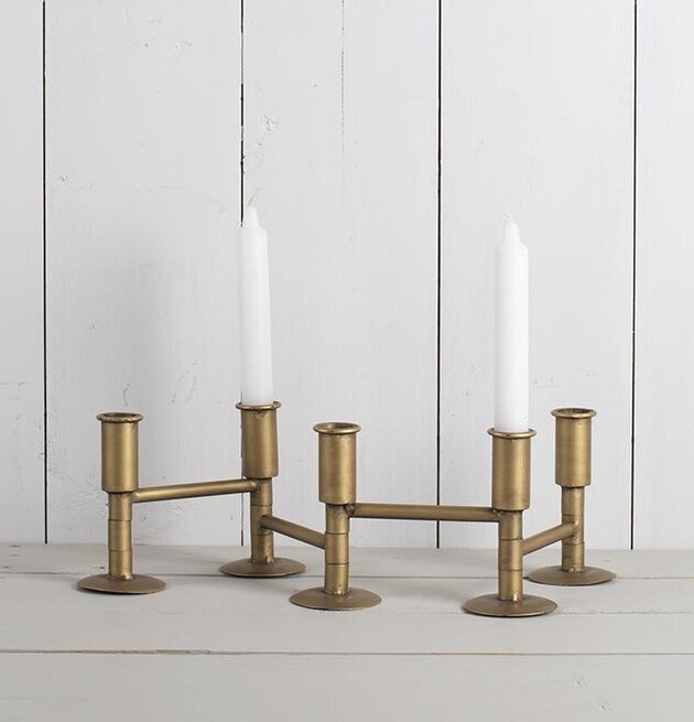 Ljusstake Vikbar från Multi Agentur i mässing på träbänk