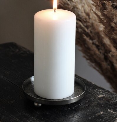 Bild av ljus på metallfat med antik finish och mönster