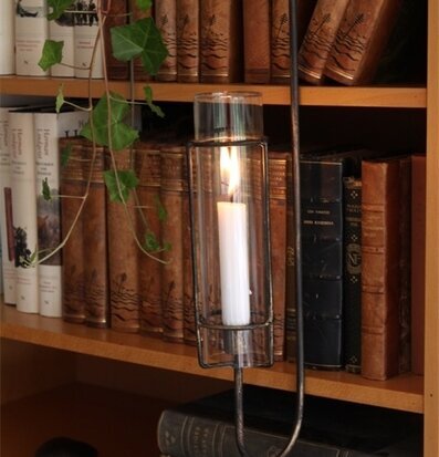 Bild av elegant ljuslykta i bokhylla med böcker