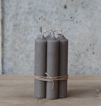 Bild av eleganta stearinljus på träbord med betongfond