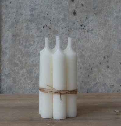 Bild av eleganta vita stearinljus mot rustik bakgrund