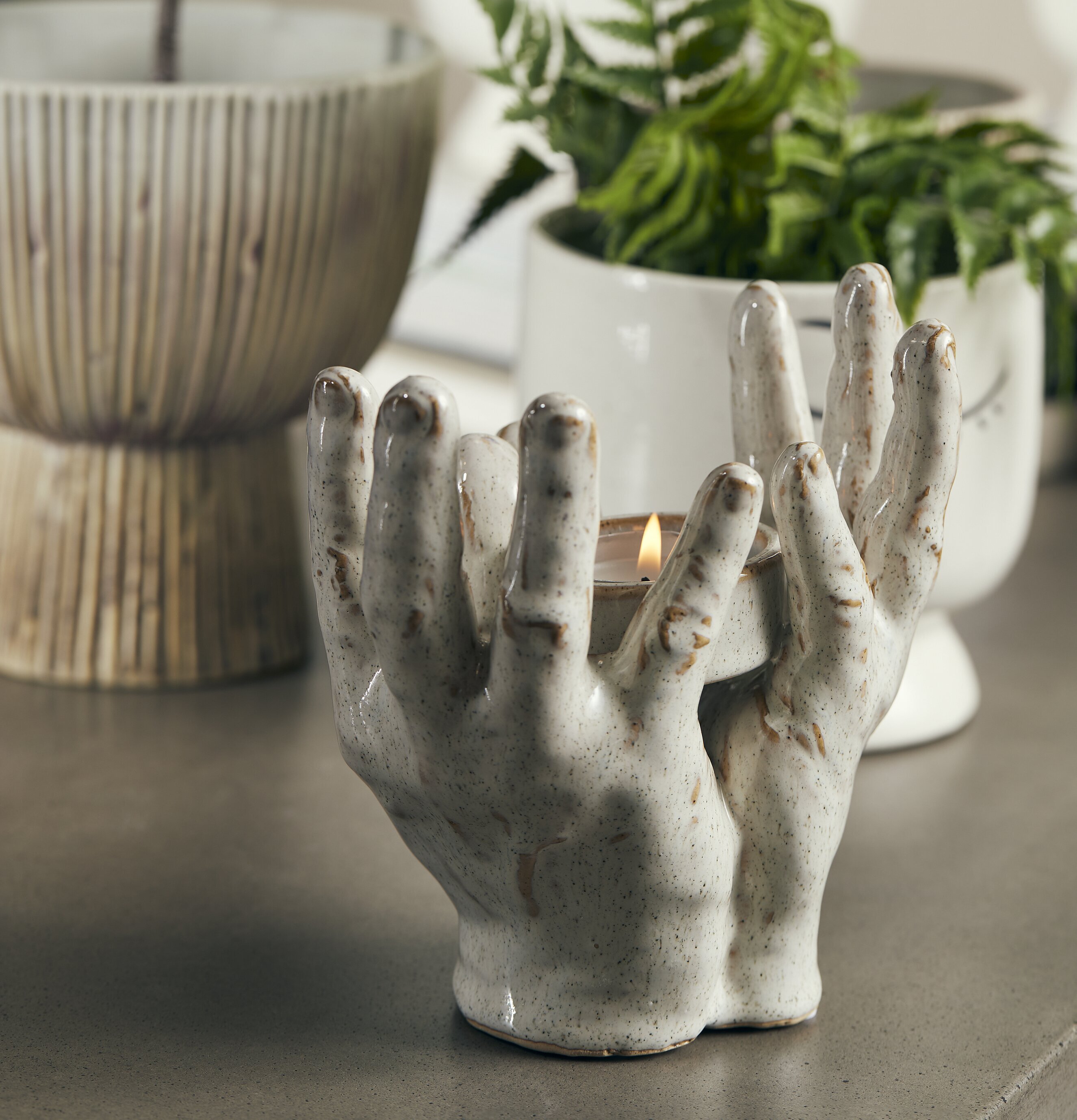 Ljushållare Händer från Bahne omgiven av gröna växter