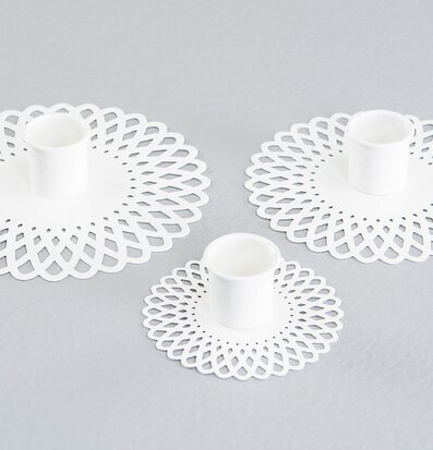 Foto av eleganta vita ljushållare i triangulärt arrangemang