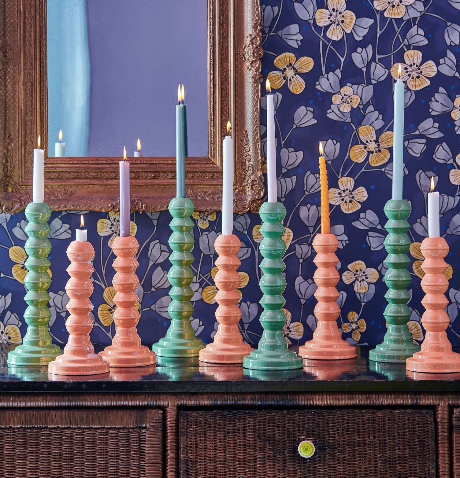 Ljusstake Emalj Orange från Rice på svart skänk med spegel