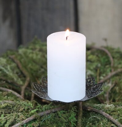 Foto av antik mässingsljushållare med ljus och mossa