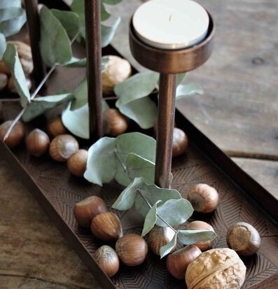 Bild av ljushållare med antik mässing och naturmaterial