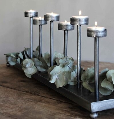 Foto av antik ljushållare i silver med eukalyptus