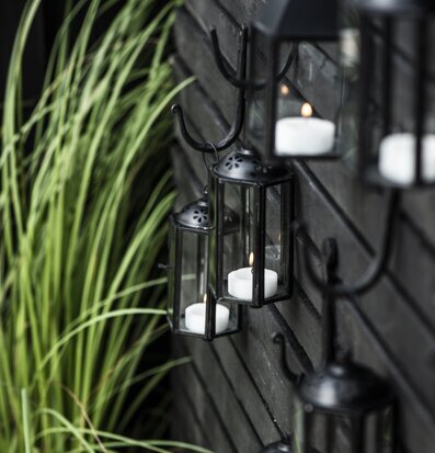 Bild av eleganta svarta lanternor på träpanel