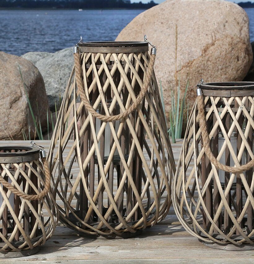 Foto av tre vackra ljuslyktor vid en sjö i naturen