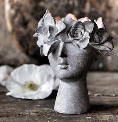 Foto av ljushållare med skulpturell design och blommor