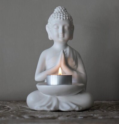 Bild av ljushållare med Buddhafigur i harmonisk miljö