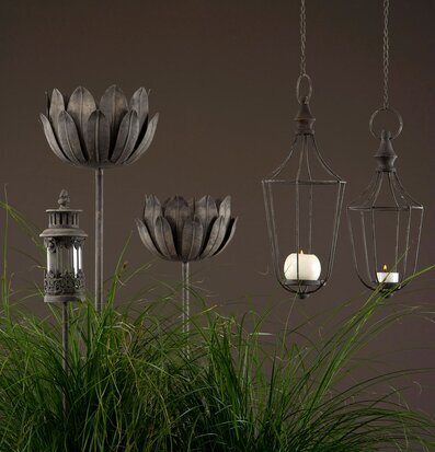 Bild av dekorativa ljuslyktor i frodig grönska