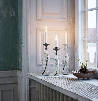 Bild av ljushållare i återvunnet glas och naturmiljö