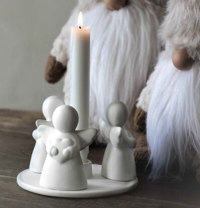 Bild av stilren ljusstake med änglastatyer i fokus