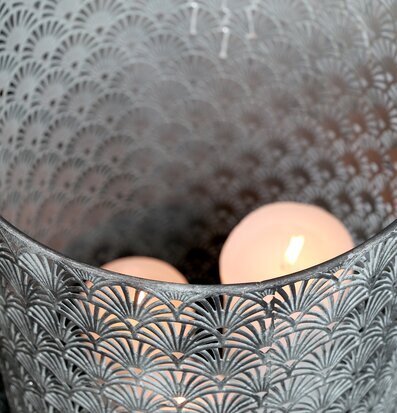 Bild av en antik zinkljuslykta med intrikat mönster