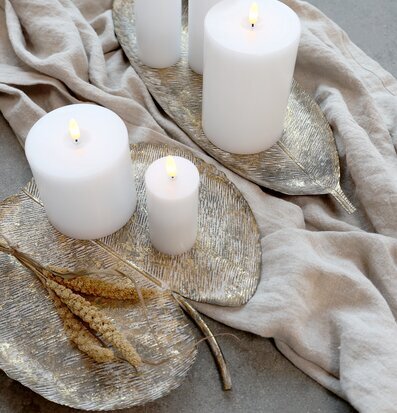 Foto av eleganta ljusarrangemang på bladformade brickor