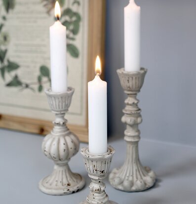 Bild av tre antikgrå ljusstakar med stearinljus