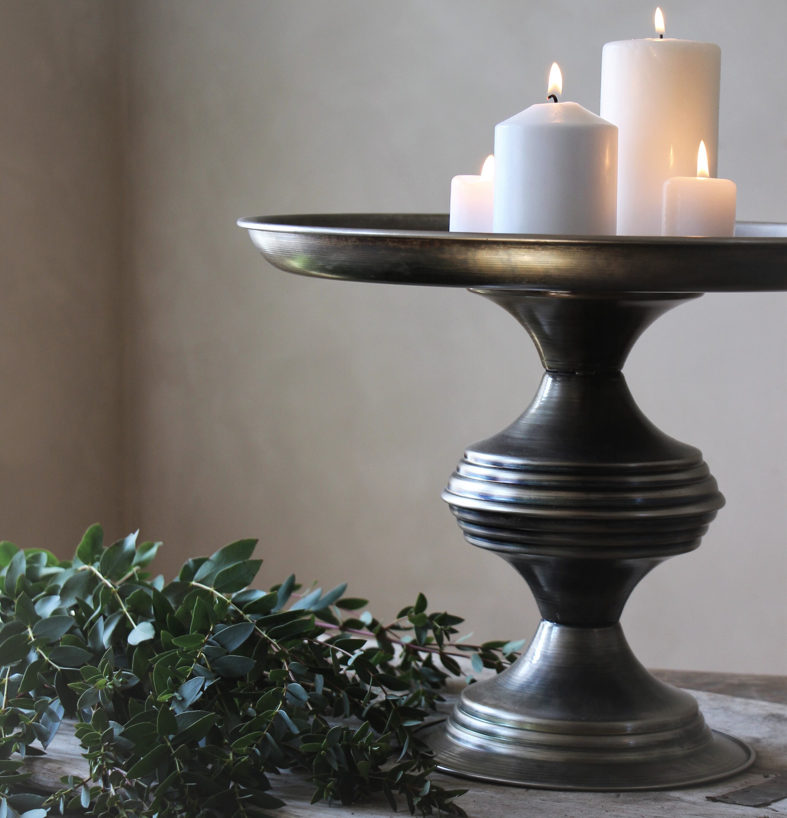 Bild av ljusstake på metallfat med stämningsfull belysning