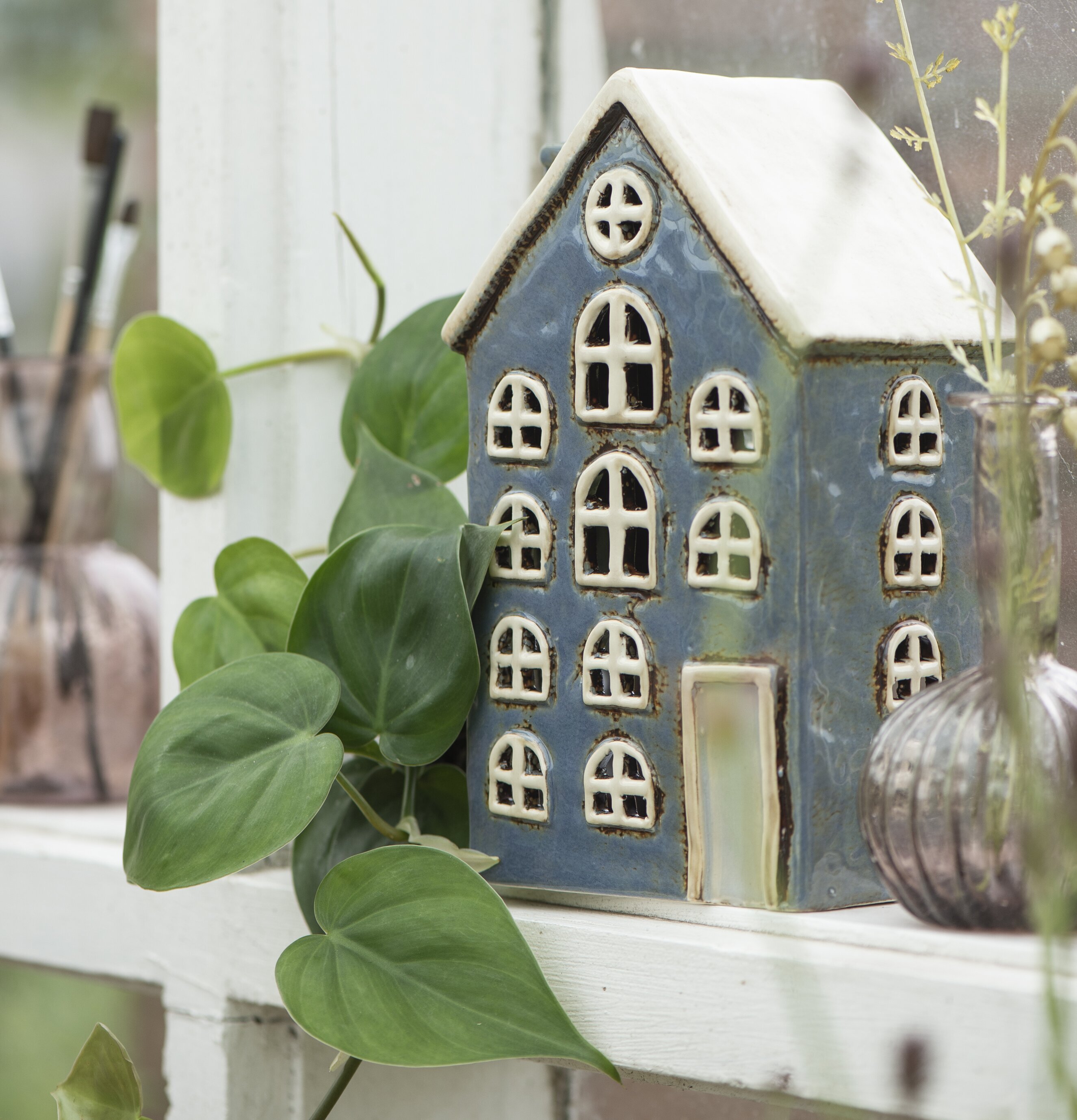 Ljuslykta Nyhavn Blå från IB Laursen på vit hylla med växter