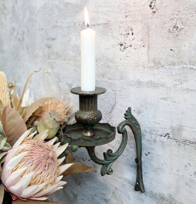 Bild av antik mässingsljusstake och torkade blommor