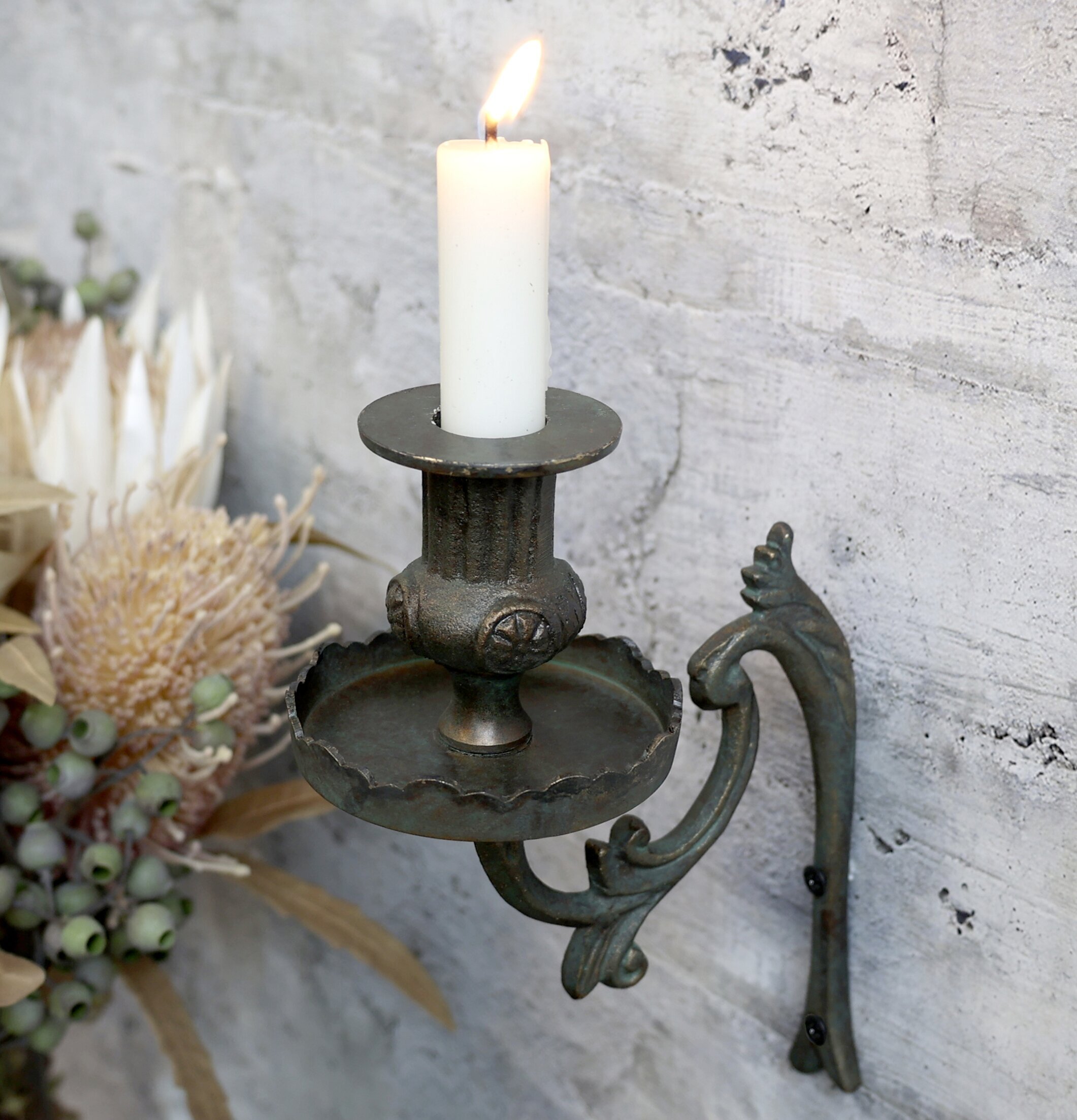 Fransk Ljusstake Antik Mässing från Chic Antique på betongvägg