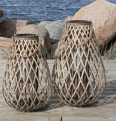 Bild av flätade ljuslyktor vid rofylld vattenmiljö