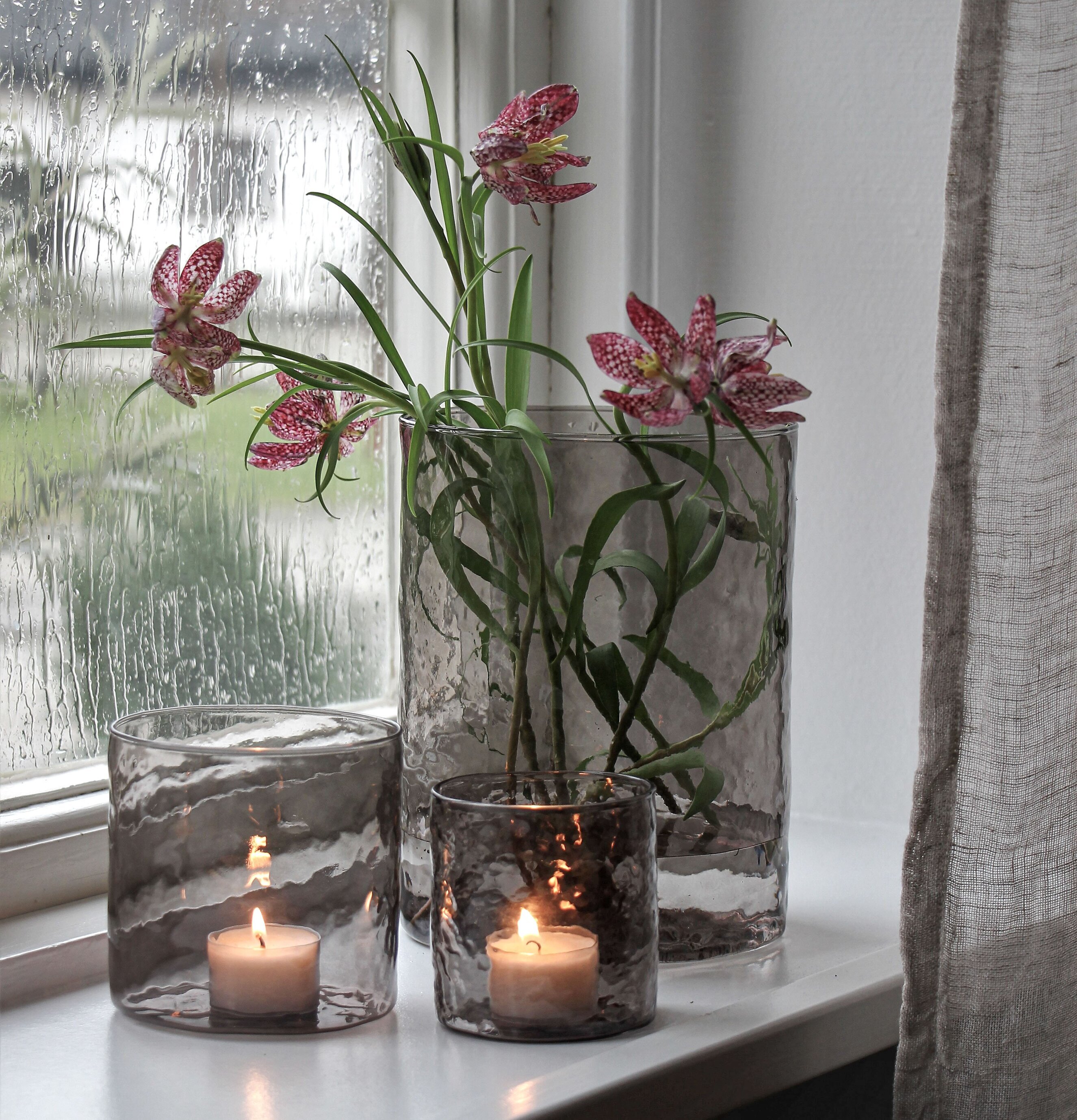 Ljuslykta Hamra Smoke 8x8 Cm från Majas Cottage på fönsterbräda