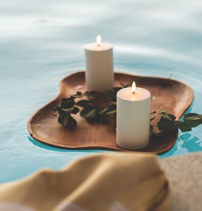 Bild av LED-blockljus på träbricka vid vattnet