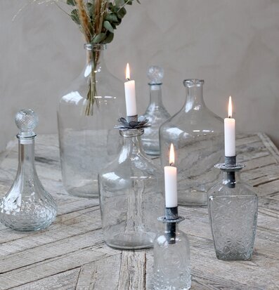 Bild av smakfullt arrangemang med glasflaskor och ljus